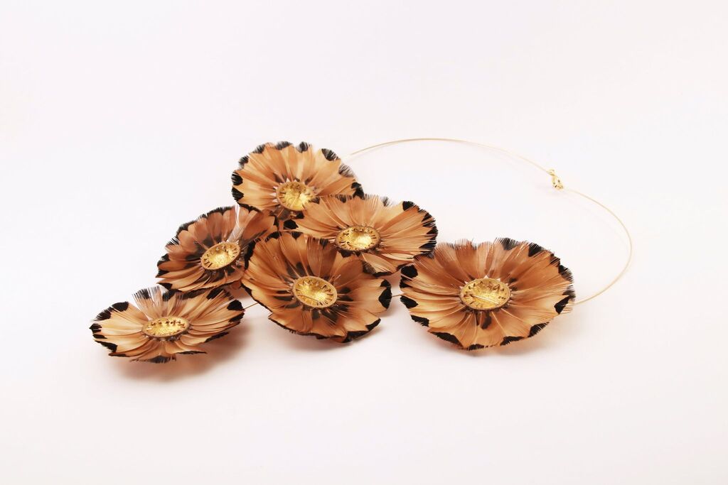 Collier cupules et plumes sur fond blanc